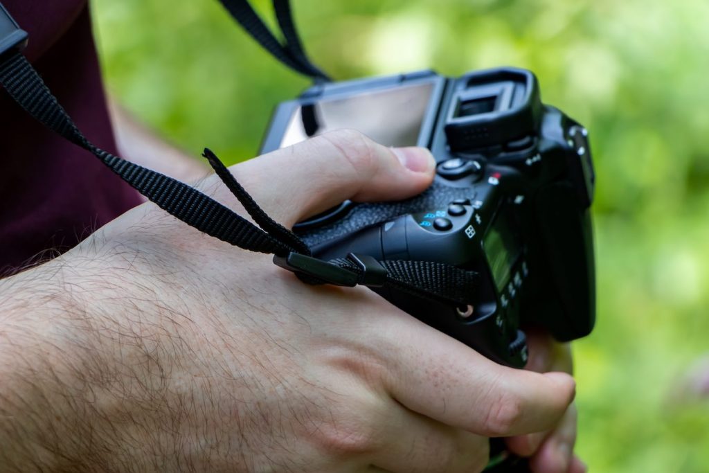 Man adjusting shutter speed and other settings on camera.